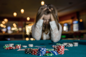 Woman sits at casino and considers gambling addiction treatment program